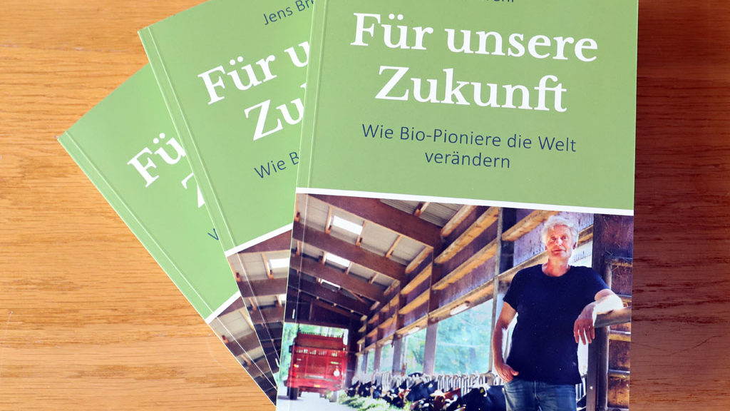 drei Exemplare des Buchs "Für unsere Zukunft - Wie Bio-Pioniere die Welt verändern" von Jens Brehl