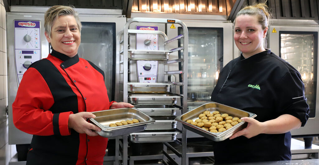 WKErBo: Zwei Frauen in der Großküche von St. Lioba mit Behältern mit bio-veganen Bällchen in der Hand.
