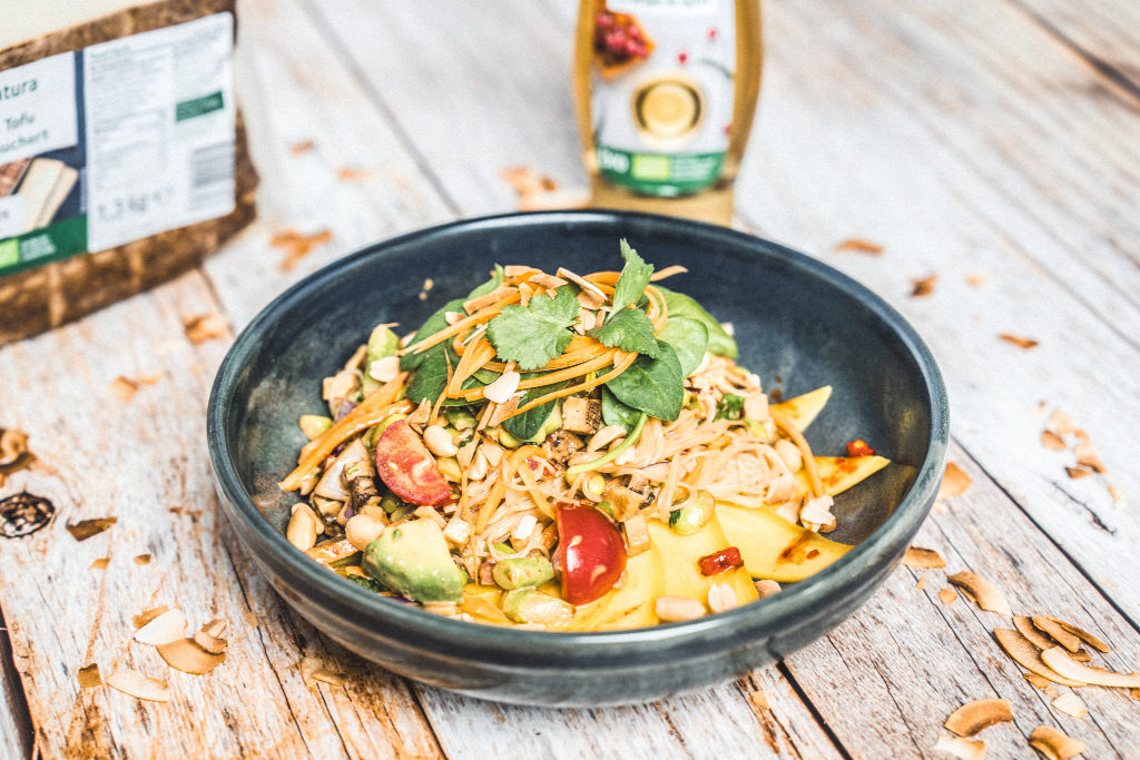 Eine Schüssel Pasta und Gemüse, im Hintergrund eine Packung Tofu = Symbolbild der Bio-Eigenmarke Natura von Transgourmet